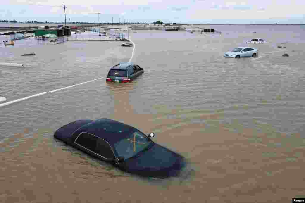 Cars sit abandoned on roads as floodwaters from the Tule River inundate the area after days of heavy rain in Corcoran, California, March 21, 2023.