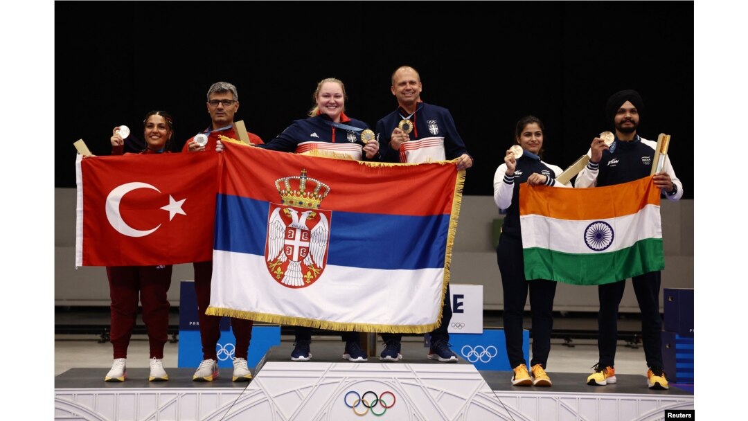 Osvajači srebrnih medalja Sevval Ilaida Tarhan iz Turske i Jusuf Dikec iz Turske, zlatne medalje Zorana Arunović iz Srbije i Damir iz Srbija i osvajači bronzanih medalja Manu Baker iz Indije i Sarabjot Sing iz Indije poziraju sa svojim nacionalnim zastavama.