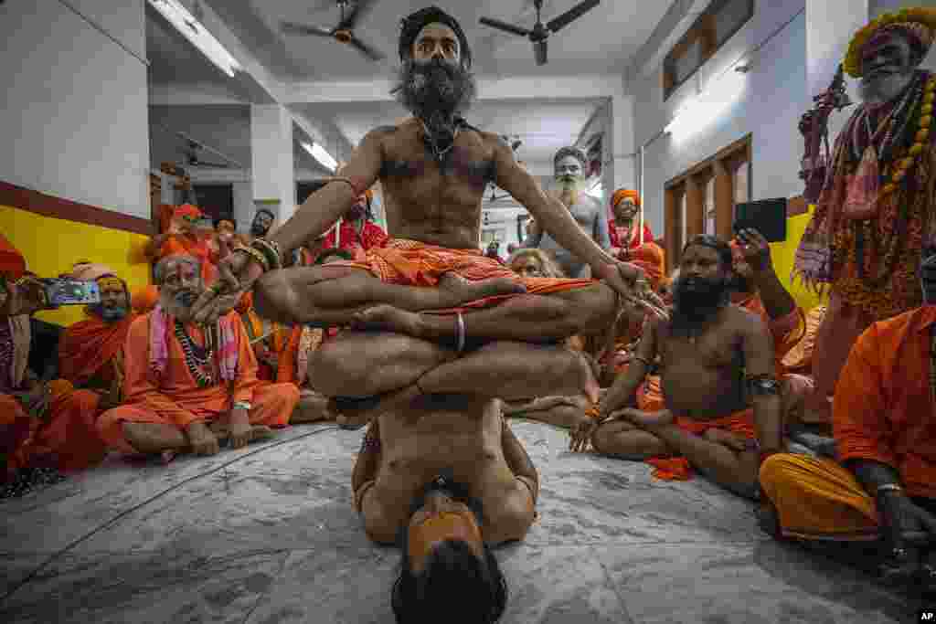 Hindu holy men display their yoga skills before media on International Day of Yoga at the Kamakhya temple in Guwahati, Assam, India.
