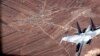 In this image from video released by the U.S. Air Force, a Russian SU-35 flies near a U.S. Air Force MQ-9 Reaper drone on July 5, 2023, over Syria.