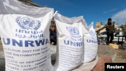 FILE - Displaced Palestinians wait to receive U.N. Relief and Works Agency aid, amid the conflict between Israel and the Palestinian Islamist group Hamas, in Rafah, in the southern Gaza Strip, March 7, 2024.