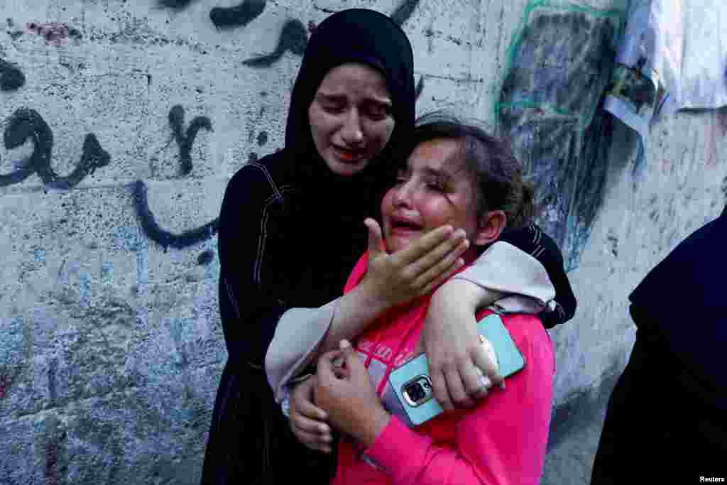 Con gái của Zakaria Abu Maamar, một thành viên của văn phòng chính trị của Hamas, được vỗ về khi em khóc trong đám tang của cha mình, sau khi ông này bị hạ sát trong một cuộc không kích, ở Khan Younis, phía nam Dải Gaza, ngày 10 tháng 10 năm 2023. 