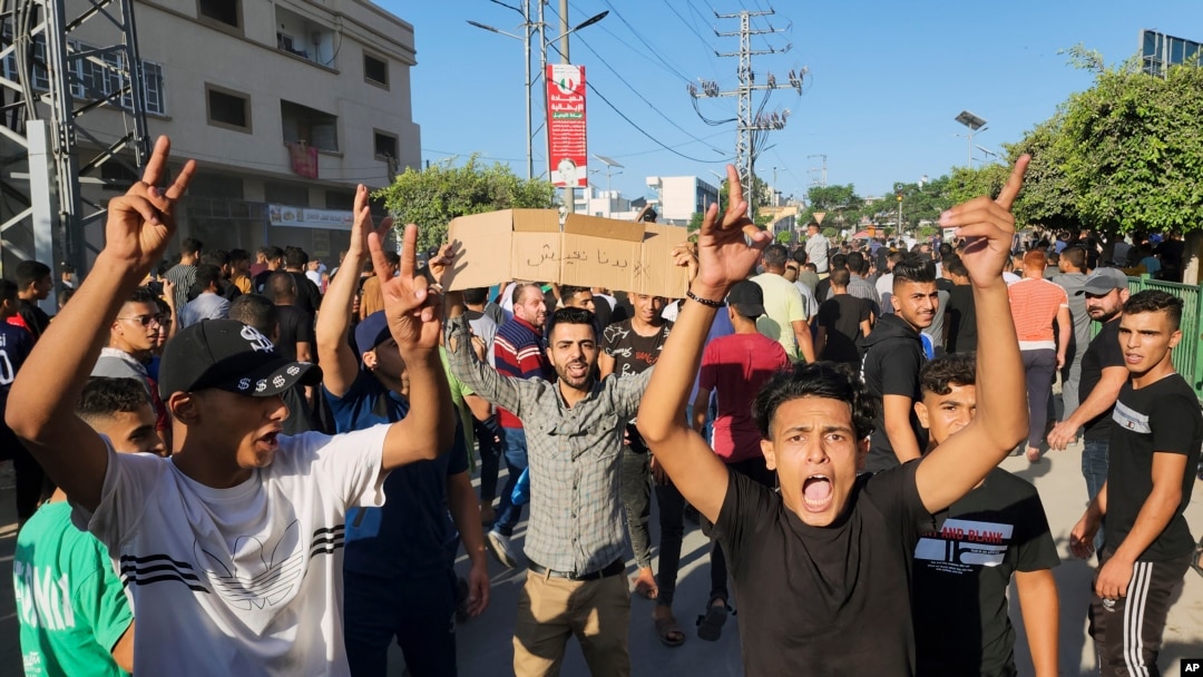 Palestinian demonstrators chant slogans during a protest against the territory's chronic power outages and difficult living conditions along the streets of Khan Younis, southern Gaza Strip, July 30, 2023.