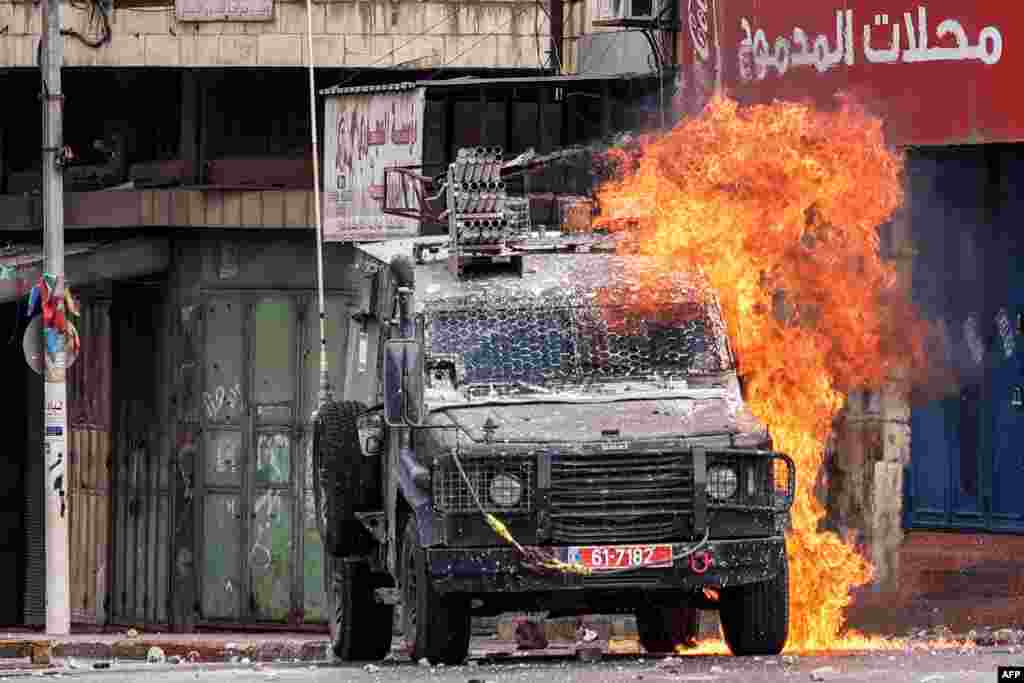 A Molotov cocktail explodes on an Israeli armored vehicle in clashes with Palestinians during an Israeli military raid in the old city of Nablus in the occupied West Bank.