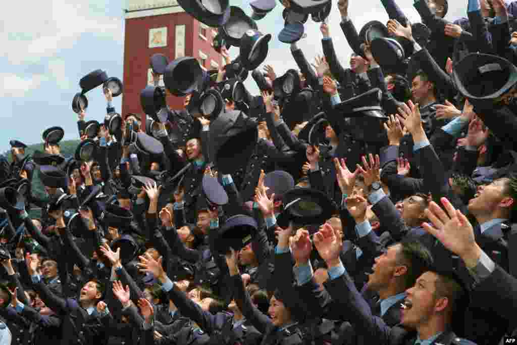 Military academy graduates throw their hats during a graduation ceremony in Taipei. Nearly 2,000 graduates from six military academy schools in Taiwan attended the ceremony.
