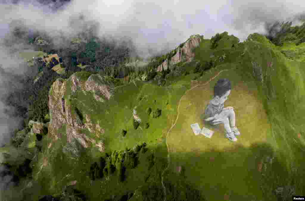 A land art painting representing a child drawing, by Swiss-French artist SAYPE, is pictured at the Chamossiare in Villars-sur-Ollon, Switzerland, July 13, 2023.