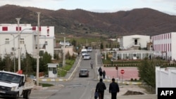 FILE - Members of Mujahedin-e Khalq walk in a street at the Ashraf-3 camp, which is a base for the People's Mujahedin Organization of Iran, in Manza, Albania, on March 4, 2020.