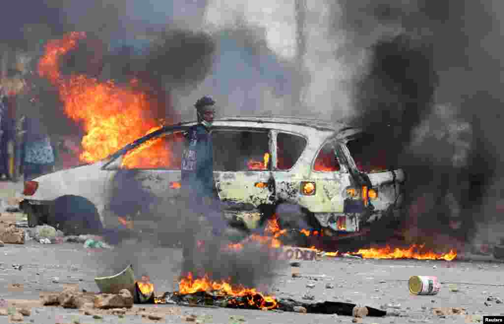 A protester looks on near a burning barricade during a "national shutdown" against the election outcome, in Maputo, Mozambique, Nov. 7, 2024.