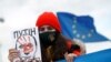 A young woman holds a drawing of Russian President Vladimir Putin during a protest against Russia's invasion of Ukraine in Niksic, Montenegro, on March 6, 2022.