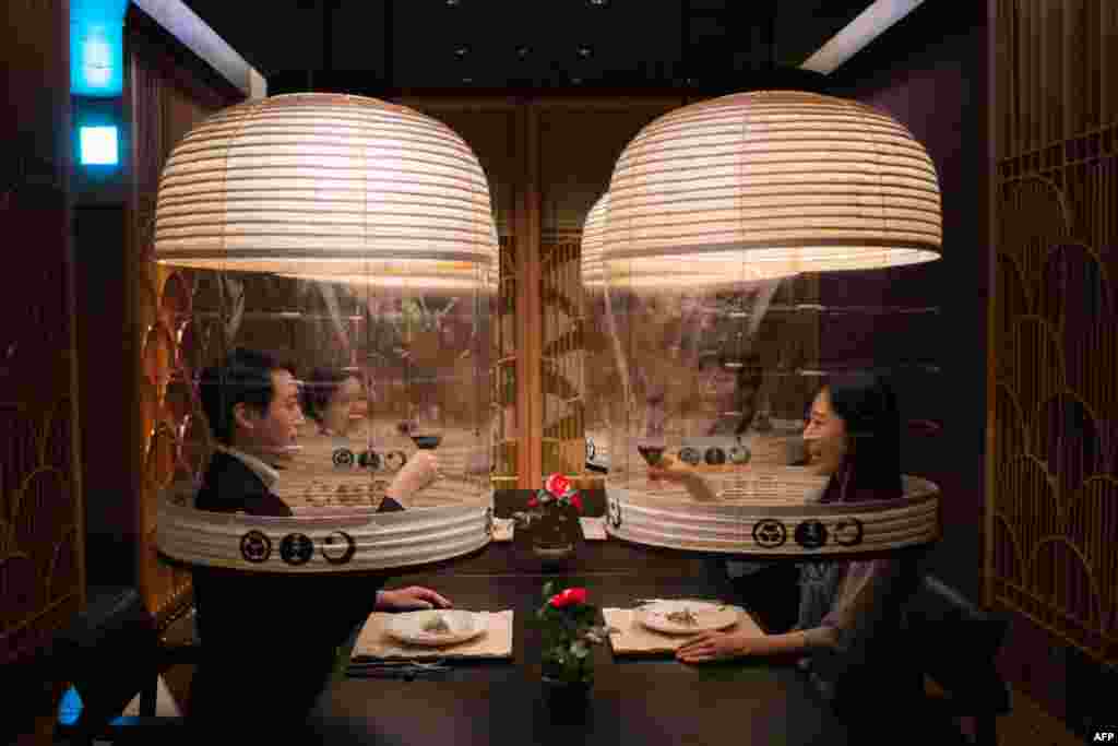 Staff members from the Hoshinoya Tokyo hotel demonstrate the "Lantern Dining Experience", where lanterns made by Kojima Shoten - a shop in Kyoto - are used to shroud diners for mask-free dining amid the Covid-19 pandemic, at the hotel in Tokyo, Japan, Feb. 28, 2022.