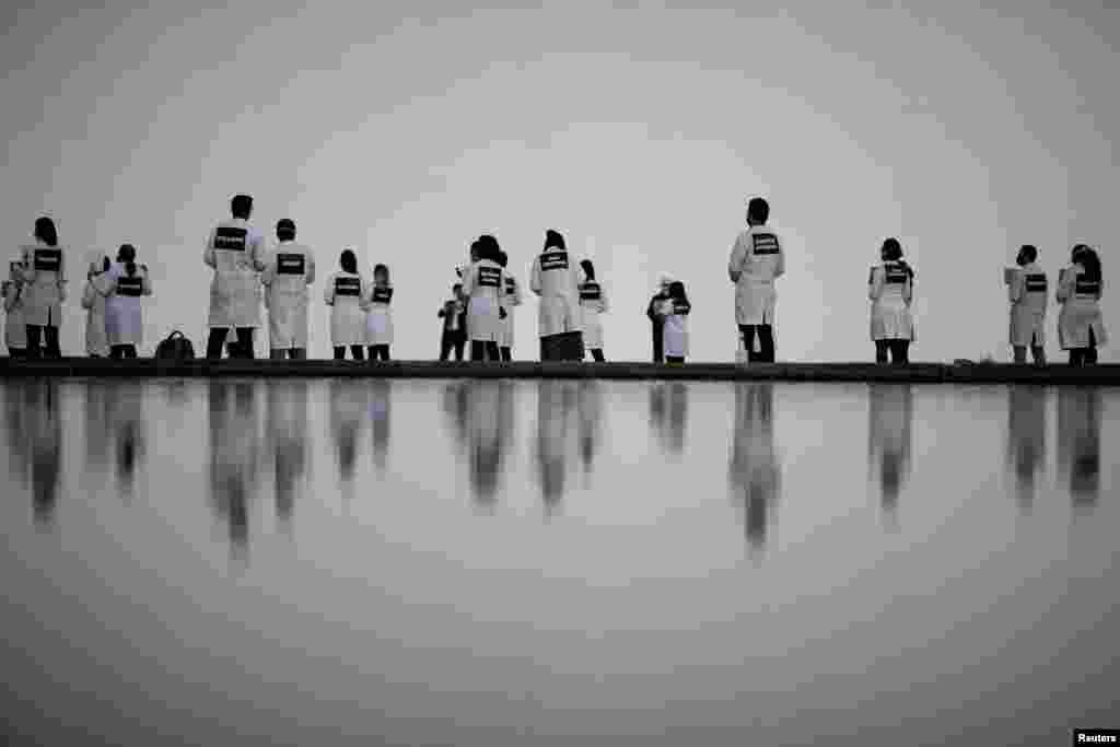 Nurses wearing protective face masks participate in a protest with signs bearing the names of healthcare professionals who died from the coronavirus disease (COVID-19) in Brasilia, Brazil, May 12, 2020.