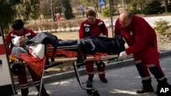 Mtu aliyejeruhiwa akiwasili katika hospitali ya mji wa Novoiavorisk, magharibi ya Ukraine baada ya Russia kushambulia Kituo cha Mafunzo ya Kijeshi magharibi ya Ukraine kinacho endesha mazoezi ya kijeshi ya NATO. western Ukraine, March 13, 2022. (AP Photo/Bernat Armangue)