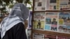 FILE - A man looks at newspaper headlines at a news stand in Bamako, Mali, June 11, 2021.