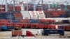 Two trucks move shipping containers at the Port of Long Beach, Feb. 17, 2015, in Long Beach, California. Signed earlier this year, the Trans-Pacific Partnership aims to lower tariffs and boost trade among 12 Pacific Rim nations; the pact has yet to go into effect.