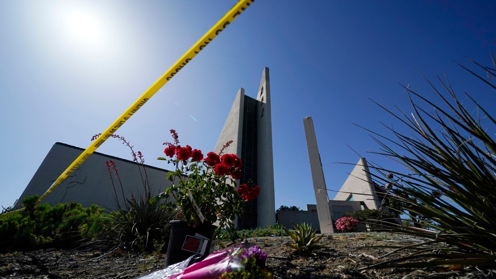 Flowers sit outside crime scene tape at Geneva Presbyterian Church on May 17, 2022, in Laguna Woods, Calif. A shooting at the church on May 15, 2022, left one dead and five injured. AP Photo.