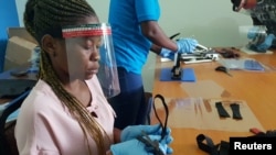 FILE - Workers prepare face shields from recycled plastics at the Zaidi Recyclers workshop in Dar es Salaam, Tanzania, May 27, 2020.