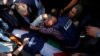 Mourners cluster near the body of Al Jazeera reporter Shireen Abu Akleh, who was shot and killed while covering an Israeli raid in the occupied West Bank town of Jenin on May 11, 2022, the Palestinian health ministry said.
