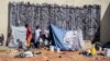 Personas desplazadas por la violencia de la guerra de pandillas en Cite Soleil se refugian en la Plaza Hugo Chávez, transformada en un refugio que ofrece condiciones insalubres, en Puerto Príncipe, Haití, el 16 de octubre de 2022.