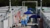 FILE - Workers wearing personal protective equipment work at a COVID-19 isolation facility, amid the pandemic, in Hong Kong, March 21, 2022. 