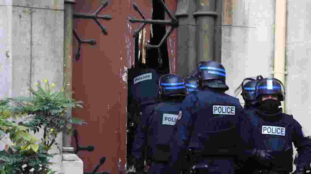 Des policiers français défoncent l’entrée d’une église au cours d’un raid dans la banlieue parisienne, Saint-Denis, 18 novembre 2015.