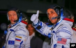 FILE - The International Space Station (ISS) crew members Joe Acaba, right, of the the U.S., and Alexander Misurkin of Russia walk after donning space suits shortly before their launch at the Baikonur Cosmodrome, Kazakhstan, Sept. 13, 2017.