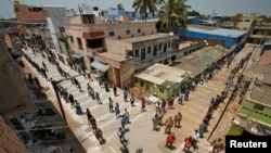 People stand on the lines by maintaining safe distance as they wait to receive free food being distributed by Central Reserve Police Force during a 21-day nationwide lockdown to slow the spreading of coronavirus in Chennai, India, April 1, 2020. 