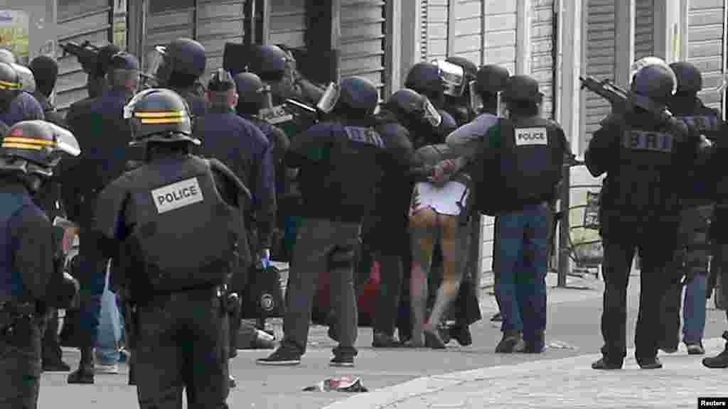 Un homme à moitié nu est emmené par les forces de sécurité lors de l’assaut à Saint-Denis, 18 novembre 2015.