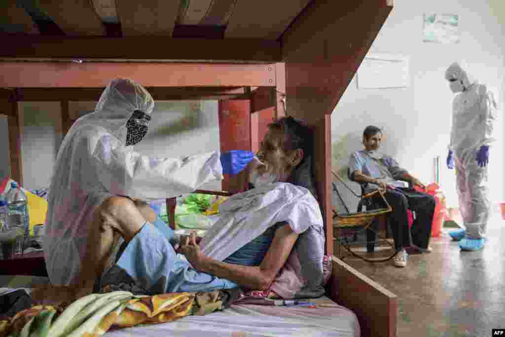 COVID-19 patients are assisted by medical staff in protective equipment at the regional hospital in Iquitos, the largest city in the Peruvian Amazon, May 9, 2020.