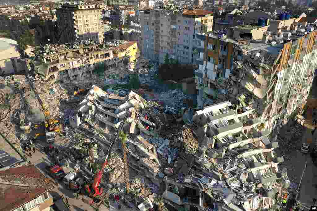 Rescue teams search for people as cranes remove debris from destroyed buildings in Antakya, southeastern Turkey.