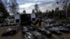 Trabajadores del cementerio descargan cuerpos de civiles muertos desde una camioneta en el cementerio de Bucha, en las afueras de Kiev, Ucrania, el 7 de abril de 2022.
