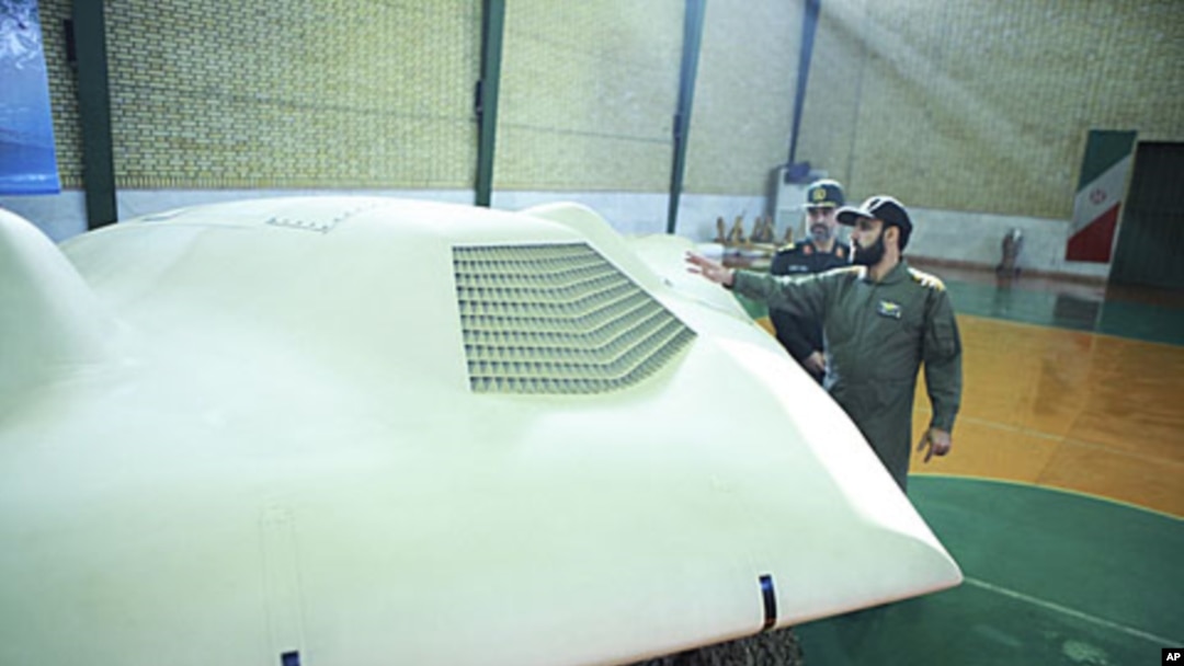 An undated picture received by Reuters December 8, 2011, allegedly shows members of Iran's revolutionary guard standing next to the captured US drone.