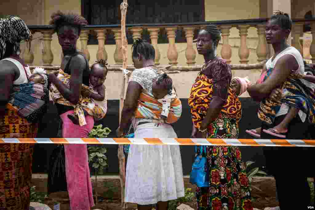 Mothers with babies line up to vote at a polling station in Freetown, Sierra Leone, March 7, 2018. (Photo: Jason Patinkin / VOA )