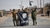  Shi'ite Popular Mobilization Forces (PMF) fighters remove an Islamic State flag after liberating the city of Al-Qaim, Iraq, Nov. 3, 2017. 