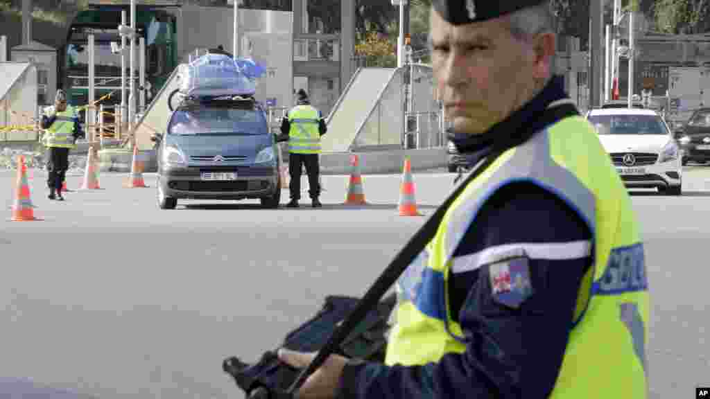 French police check vehicles at the France Italy border in La Turbie, southeastern France, Nov. 14, 2015.