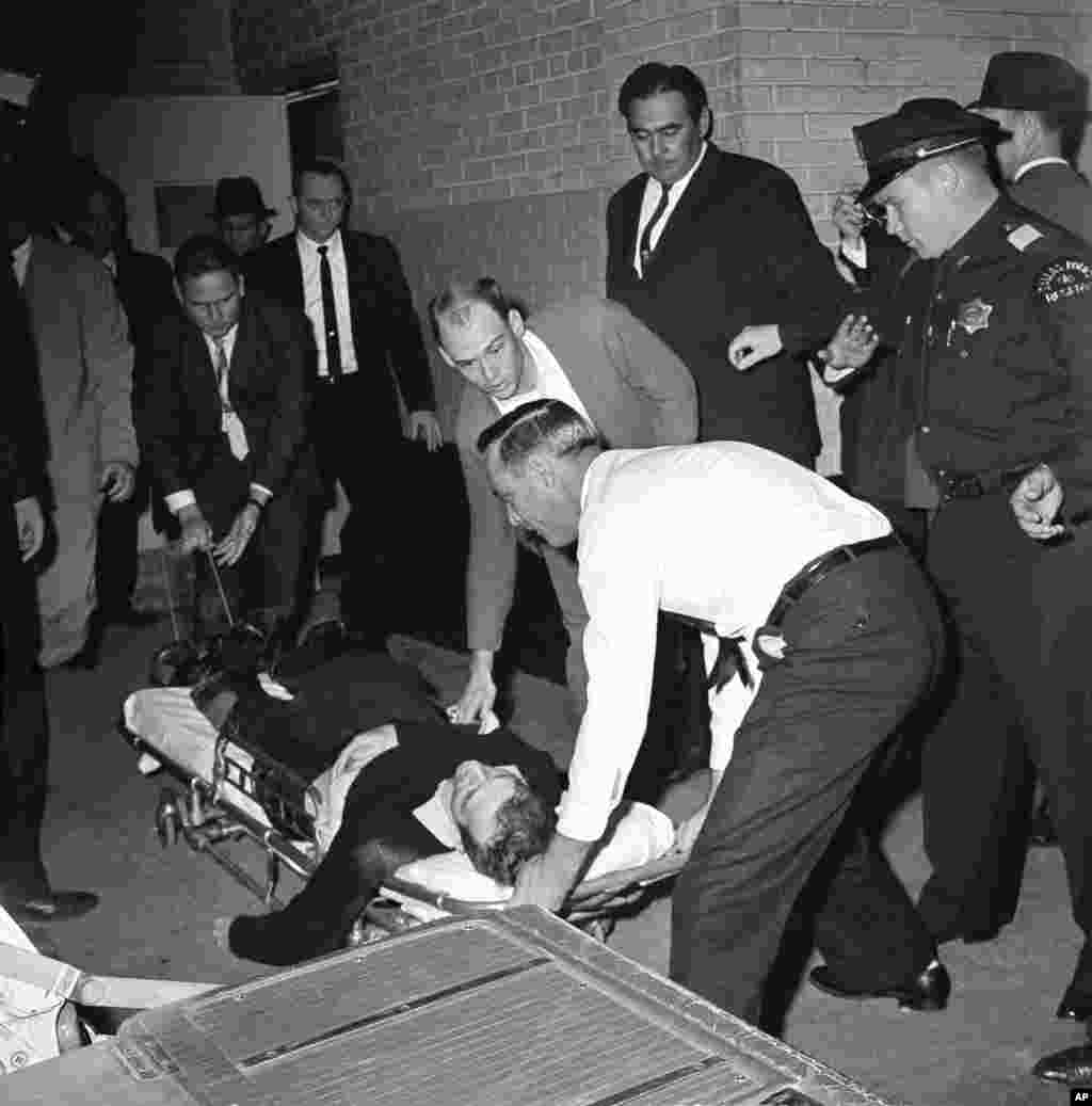 Lee Harvey Oswald, accused assassin of President John F. Kennedy, is placed on a stretcher after being shot in the stomach in Dallas, Texas, Nov. 24, 1963.