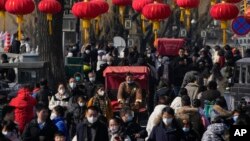 2023年1月30日，中國放棄了對新冠病毒的“零容忍”政策後，北京後海一條熙熙攘攘的街道，傳統的三輪兒在人群中穿行。(美聯社）
