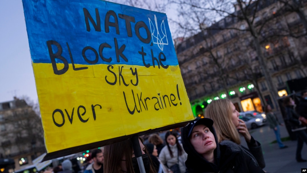 FILE - A protester holds a sign calling on NATO to establish a no-fly zone over Ukraine, during a rally in Paris, France, Feb. 26, 2022.
