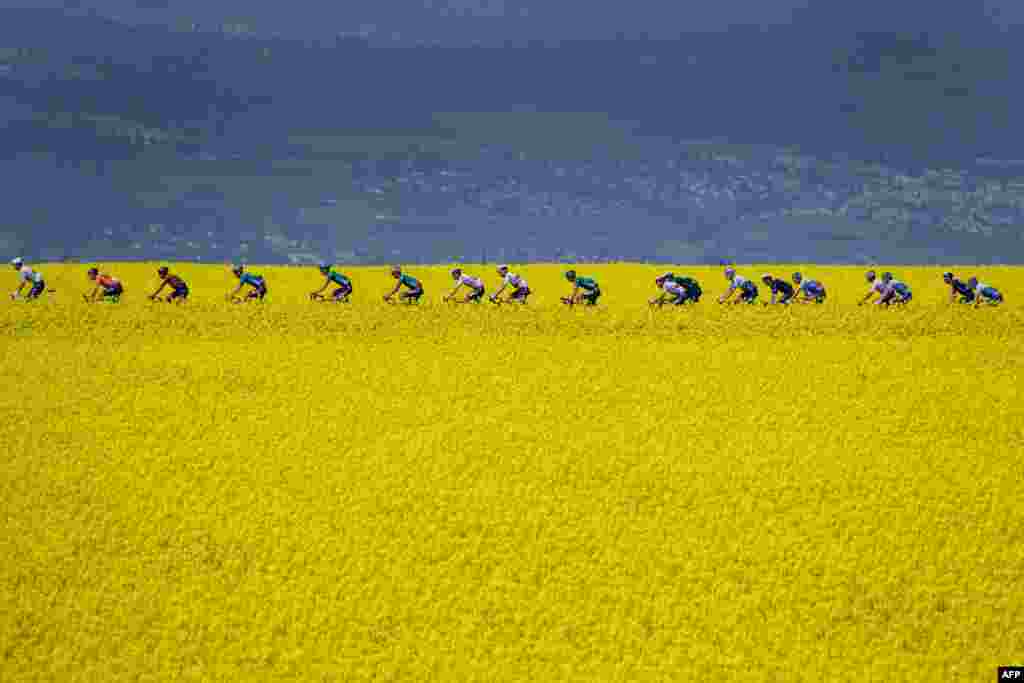 The pack rides during the third stage of the Tour de Romandie UCI World Tour 2022 cycling race near Valbroye, western Switzerland, April 29, 2022.