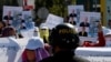 FILE - A police officer blocks workers from the NagaWorld casino holding placards during a protest outside the National Assembly building after several union members were arrested, in Phnom Penh, Jan. 4, 2022.