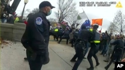Esta imagen del video de una cámara corporal usada por la policía del motín del 6 de enero en el Capitolio de los EEUU se mostró como una exhibición del comité mientras la comisión selecta de la Cámara que investigaba el ataque del 6 de enero en el Capitolio de los EEUU celebró una audiencia el 9 de junio. 2022.