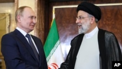 FILE - Russian President Vladimir Putin, left, shakes hands with Iranian President Ebrahim Raisi prior to their talks at the Saadabad palace, in Tehran, July 19, 2022. (Kremlin Pool Photo via AP)