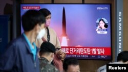 25일 한국 서울역 이용객들이 북한 단거리 탄도미사일 발사 TV 뉴스를 시청하고 있다. 