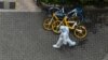 A worker wearing personal protective equipment walks on a street during a COVID-19 coronavirus lockdown in the Jing'an district in Shanghai on April 25, 2022. 