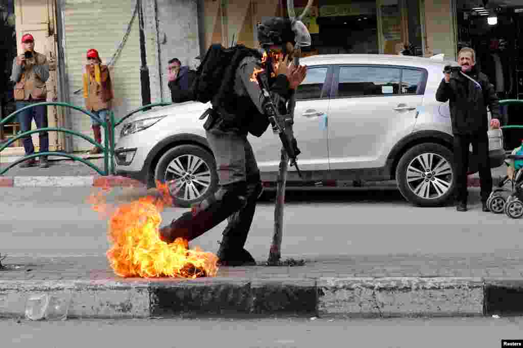 An Israeli border policeman is on fire as he is hit with a molotov cocktail thrown by Palestinian demonstrators during a protest against the U.S. President Donald Trump's Middle East peace plan, in Hebron in the Israeli-occupied West Bank, Feb. 3, 2020.