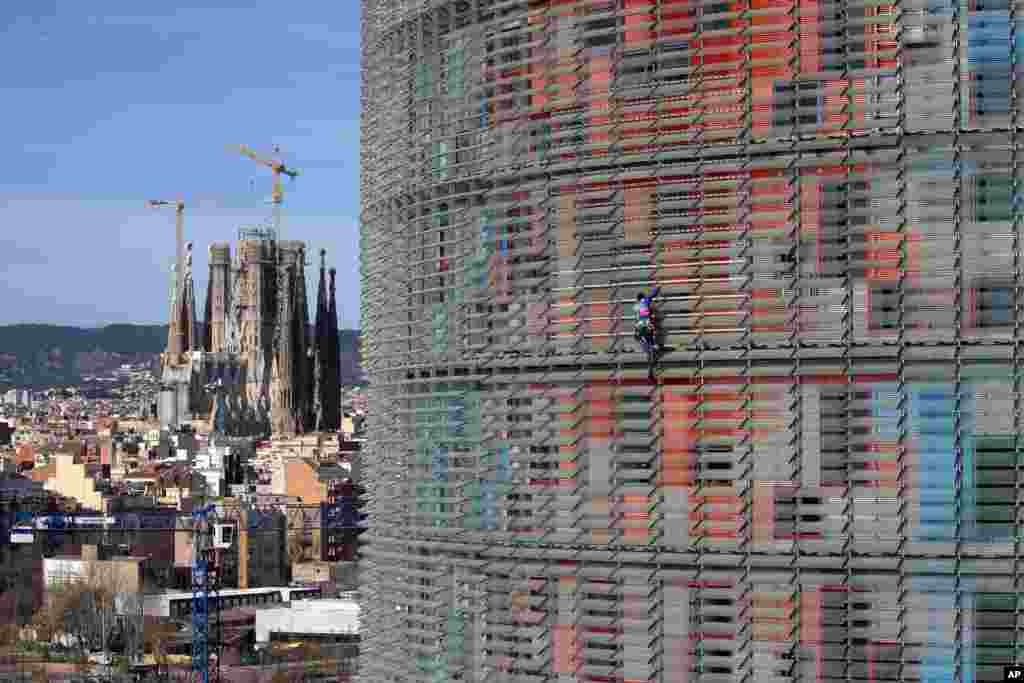 French urban climber, Alain Robert, scales the 144 meters (472 ft) of the Glories tower in Barcelona, Spain. Robert, known as Spiderman climbed up he tower in about 20 minutes. Spanish authorities briefly detained him after the stunt.