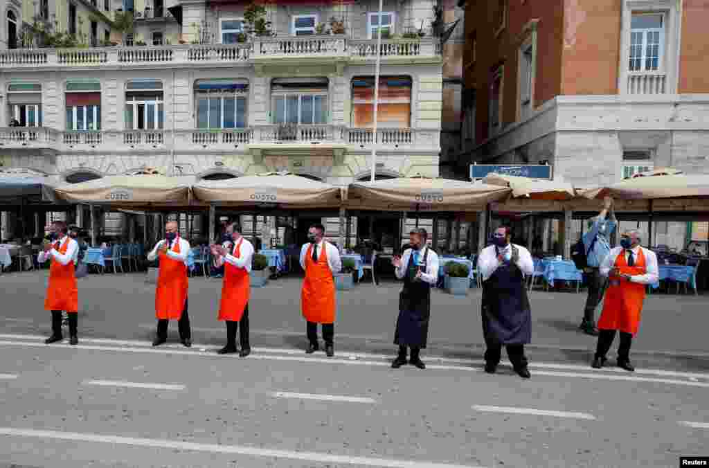 Workers applaud to thank health workers for their battle against the coronavirus disease (COVID-19) before their restaurants' reopening on the waterfront in Naples, as Italy eases some of the lockdown measures put in place during the COVID-19 pandemic.