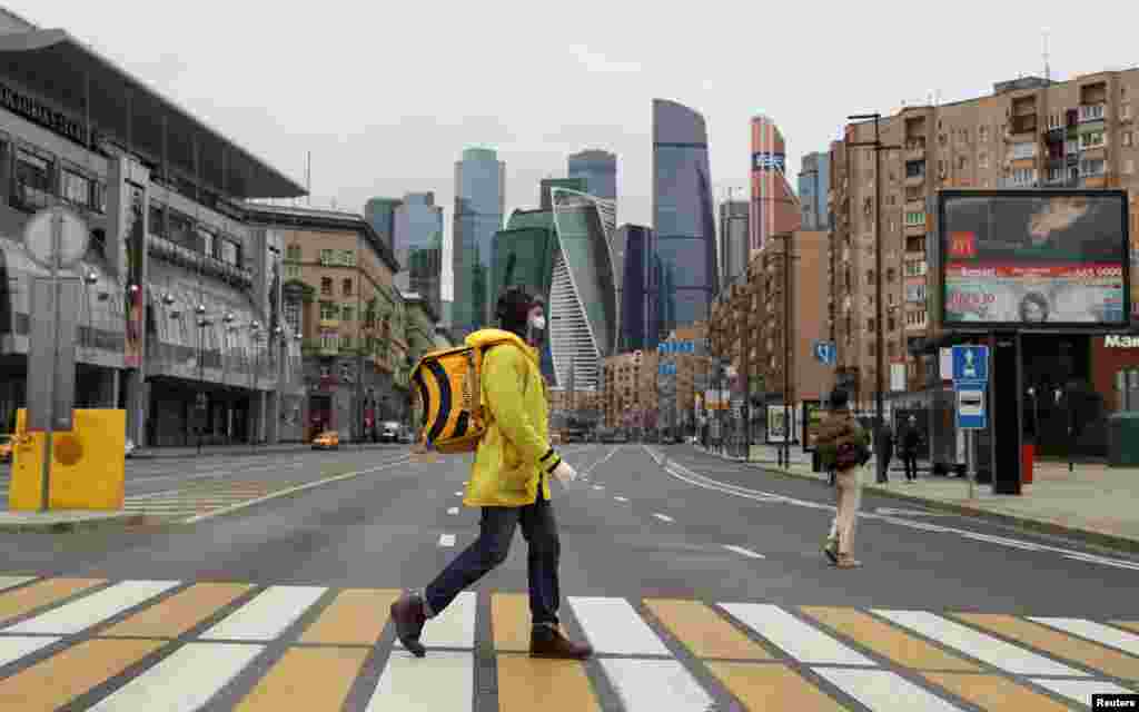 A Yandex.Eats food delivery courier crosses a street during a partial lockdown to prevent the spread of coronavirus disease (COVID-19), in Moscow, Russia.