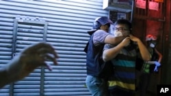 一名警察2019年8月7日在香港深水埗警署外的警民對峙中逮捕了一名示威者。