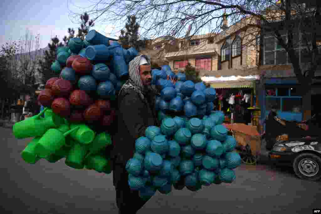 A man carries plastic pitchers on a street in Kabul, Afghanistan.
