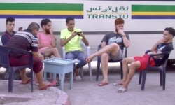 FILE - Young men are seen at a bus stop cafe in Tunis, Tunisia. Unemployment reaches 30 percent in some parts of Tunisia. (Lisa Bryant/VOA)